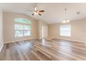Spacious living area featuring wood floors, ceiling fan, and ample natural light from multiple windows at 2104 Remington Pointe Blvd, Kissimmee, FL 34743
