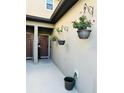 A cozy entrance with hanging potted plants and neutral-colored walls, next to an entrance door at 2285 Seven Oaks Dr, St Cloud, FL 34772