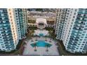 Aerial view of a community pool surrounded by palm trees and lounge chairs at 231 Riverside Dr # 708, Daytona Beach, FL 32117