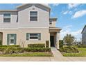 Charming two-story townhome with lush landscaping, a welcoming entrance, and convenient parking at 233 Primrose Dr, Davenport, FL 33837
