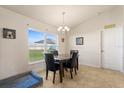 Bright dining area featuring a modern chandelier, a dining table with four chairs, and natural light at 2412 Twin Lake View Rd, Winter Haven, FL 33881