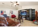 Comfortable living room with tile flooring, ceiling fan, large entertainment center, and cozy furnishings at 2412 Twin Lake View Rd, Winter Haven, FL 33881