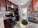 Updated kitchen features granite countertops, stainless steel appliances, and stylish backsplash at 2480 Alamanda Ave, Deltona, FL 32738