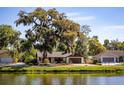 Scenic view of the home's exterior complemented by a tranquil waterfront setting at 2713 Lime Tree Dr, Edgewater, FL 32141