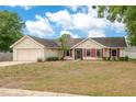 Charming single-story home with red shutters, a well-manicured lawn, and an attached two-car garage at 2910 S Whisperbay Ct, Oviedo, FL 32765