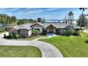 Well-maintained home featuring a circular driveway, mature landscaping, and a welcoming facade at 29150 Beauclaire Dr, Tavares, FL 32778