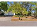 Front of home featuring a two-car garage, brick accents, mature trees and landscaping at 4366 Roanne Dr, Orlando, FL 32817