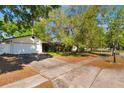 View of the brick and siding home with a wide driveway and mature shade trees at 4366 Roanne Dr, Orlando, FL 32817