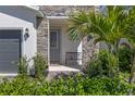 Inviting entryway with stone accents, lush landscaping, and a cozy bench at 4630 Cragmere Loop, Clermont, FL 34711