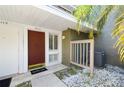 Inviting entryway with a vibrant red door, white trim, and decorative welcome mat at 6114 Peregrine Ave # D03, Orlando, FL 32819