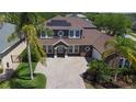 An aerial view shows the house's roof and solar panels, the brick driveway, and the front yard landscaping at 7299 Vista Park Blvd, Orlando, FL 32829