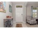 Bright entryway featuring a neutral color palette, a decorative console table, and a patterned accent chair at 9731 Pepper Tree Trl, Wildwood, FL 34785