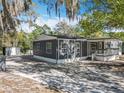 Charming single-story home with gray siding, white trim, and a welcoming front porch and a detached storage shed at 1041 Osceola Trl, Casselberry, FL 32707