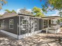 Side view of a gray home, showing a covered porch, white trim, and well-lit windows at 1041 Osceola Trl, Casselberry, FL 32707