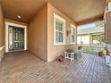 Inviting front porch featuring brick flooring, a stylish front door, and comfortable seating with decorative plants at 120 Crepe Myrtle Dr, Groveland, FL 34736