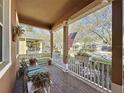 Relaxing front porch with brick flooring, white railings, comfortable seating, and views of the neighborhood at 120 Crepe Myrtle Dr, Groveland, FL 34736