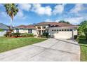 Inviting one-story home with a well-maintained lawn, mature landscaping, and an attached two-car garage at 14149 Islamorada Dr, Orlando, FL 32837