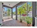 Charming front porch with white railings, plants, and view of the neighborhood street at 14209 Lake Live Oak Dr, Orlando, FL 32828