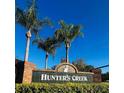 Hunter's Creek community sign with palm trees set against a clear blue sky at 14339 Windchime Ln, Orlando, FL 32837