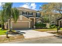 Attractive two-story home featuring a well-kept lawn, two-car garage, and a welcoming facade at 14931 Hawksmoor Run Cir, Orlando, FL 32828