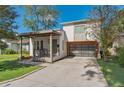 Charming two-story home with a glass panel garage door, inviting front porch, and modern design elements at 1511 E Esther St, Orlando, FL 32806