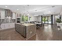 Open concept kitchen featuring a central island, stainless steel appliances, and seamlessly connecting to the living area at 1511 E Esther St, Orlando, FL 32806