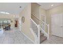 Inviting foyer with staircase, neutral tones, and marble-look tile flooring at 1555 Flange Dr, Davenport, FL 33896