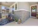 Inviting covered front porch featuring brick accents, rocking chairs, and a welcoming entrance with stylish decor at 16089 Parkwyn St, Winter Garden, FL 34787