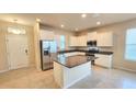 Bright kitchen featuring white cabinets, granite countertops, stainless steel appliances, and a center island at 16749 Harper Cove Dr, Winter Garden, FL 34787