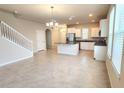 Spacious open-concept living area with tile flooring, staircase, and bright natural light at 16749 Harper Cove Dr, Winter Garden, FL 34787