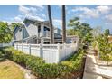 This is a bright exterior view of a charming home surrounded by mature trees and a white fence at 1709 Winter Green Blvd, Winter Park, FL 32792