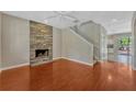 Open floor plan living room with wood floors and decorative stone fireplace feature at 2005 E Grant Ave, Orlando, FL 32806