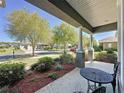 Covered front porch with stylish columns and a beautifully landscaped garden, creating a serene outdoor space at 228 Bayou Bend Rd, Groveland, FL 34736