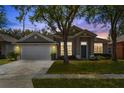 Attractive single-story home featuring a neatly manicured lawn and a two-car garage, captured at dusk at 2867 Oconnell Dr, Kissimmee, FL 34741