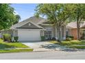 Well-maintained single-story home with a two-car garage and manicured lawn at 2867 Oconnell Dr, Kissimmee, FL 34741