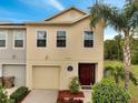 Exterior view of a two-story townhome featuring neutral paint, a garage, and well-maintained landscaping at 2906 Clarabelle Ct, Kissimmee, FL 34743