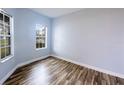 Bright bedroom featuring wood-look flooring and two windows offering ample natural light at 3209 Hanley St, Deltona, FL 32738