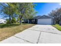 Inviting single-story home with a large driveway and attached two-car garage at 3209 Hanley St, Deltona, FL 32738