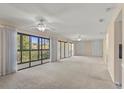 Spacious living room with neutral carpet, ceiling fans, sliding glass doors to the balcony, and natural light at 429 Sheoah Blvd # 3, Winter Springs, FL 32708