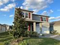 Charming gray two-story home featuring red shutters and a well-maintained lawn at 5384 Palomino Pl, Apopka, FL 32712