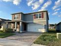 Two-story gray home with red shutters and a brick driveway leading to a two-car garage at 5384 Palomino Pl, Apopka, FL 32712