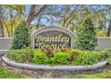 An elegant community sign for Brantley Terrace surrounded by lush greenery and colorful plants at 581 Brantley Terrace Way # 209, Altamonte Springs, FL 32714