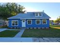 Charming blue house with freshly cut lawn, clean white trim, and new gray roof on a sunny day at 604 Missouri Ave, St Cloud, FL 34769