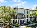 Corner lot featuring a two-story townhome with metal roof, charming balconies, and green landscaping at 604 Mulberry Ave # 1201, Kissimmee, FL 34747