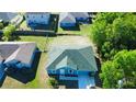 Aerial view of a well-maintained blue house with a green roof in a residential neighborhood at 608 Robin Ln, Kissimmee, FL 34759