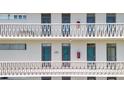 White apartment building featuring balconies with patterned railings and multiple access doors at 700 Melrose Ave # L-23, Winter Park, FL 32789