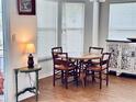 Charming dining area with a round wooden table, four chairs, and natural light from a window at 72 Saint Kitts Cir, Winter Haven, FL 33884