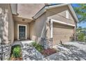 Stylish front exterior with stone accents, neutral colors, a two-car garage, and well-maintained landscaping at 7219 Rafanelli Ct, Orlando, FL 32818