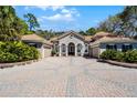 Beautiful home featuring a circular brick driveway, double front doors, and meticulously maintained landscaping at 8713 Shimmering Pine Pl, Sanford, FL 32771