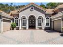 Close-up of a lovely home with arched windows, columns, double front doors, and circular detailing at 8713 Shimmering Pine Pl, Sanford, FL 32771